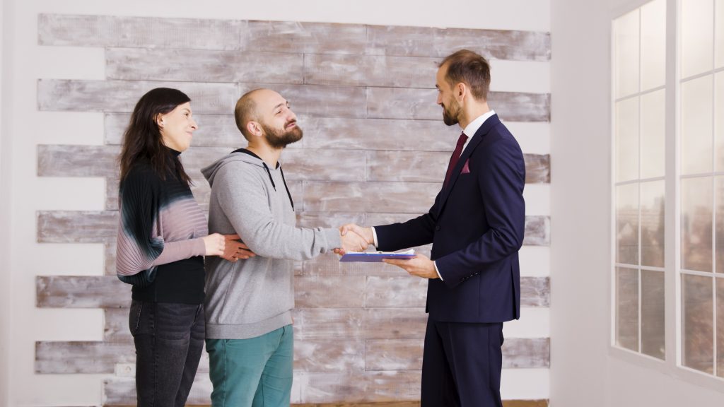 letting agent shaking hands with home buyers